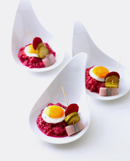 Beef tartare with quail egg on spoons