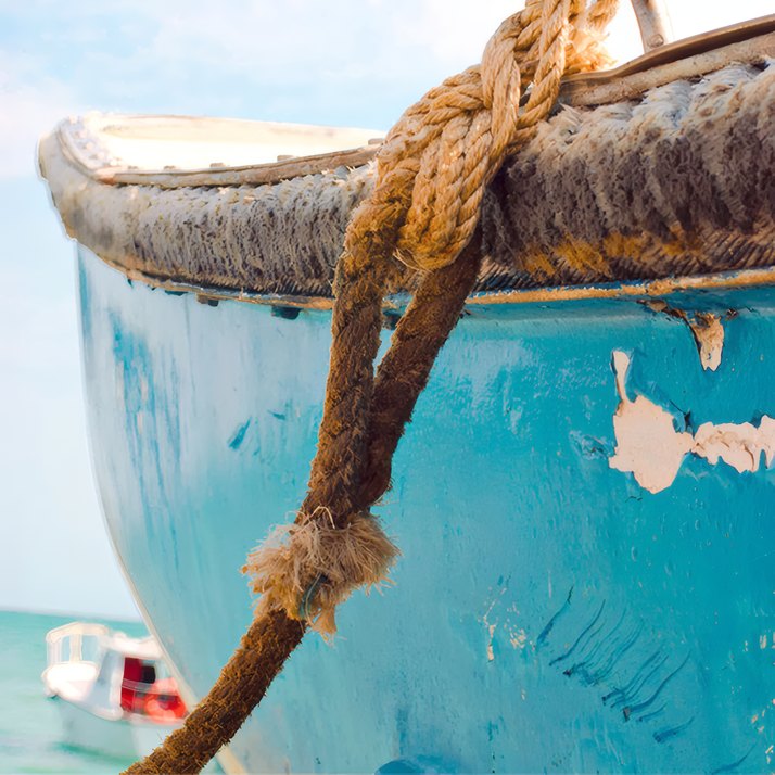 A rope coiled on the side of a fishing boat