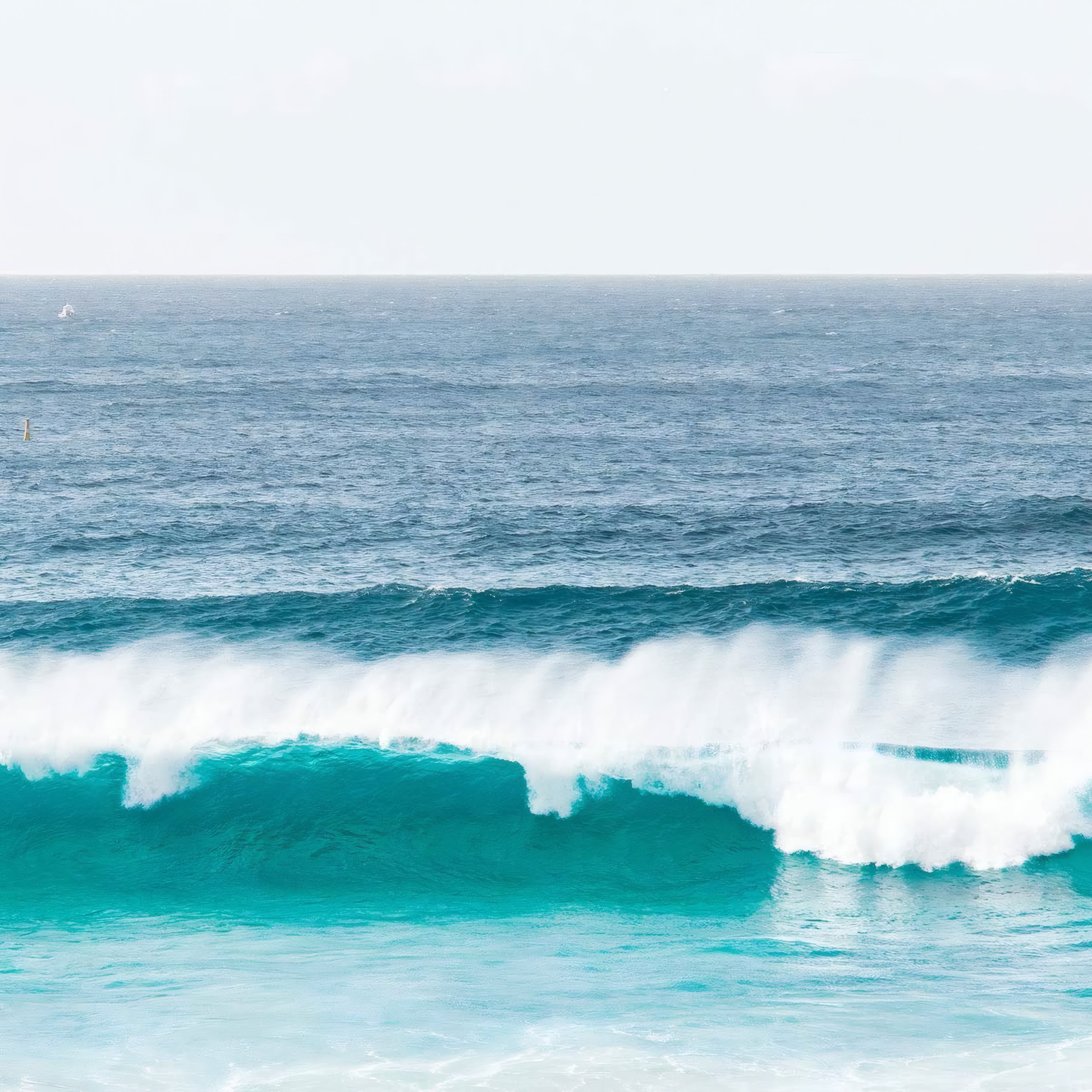 A turquoise wave breaking