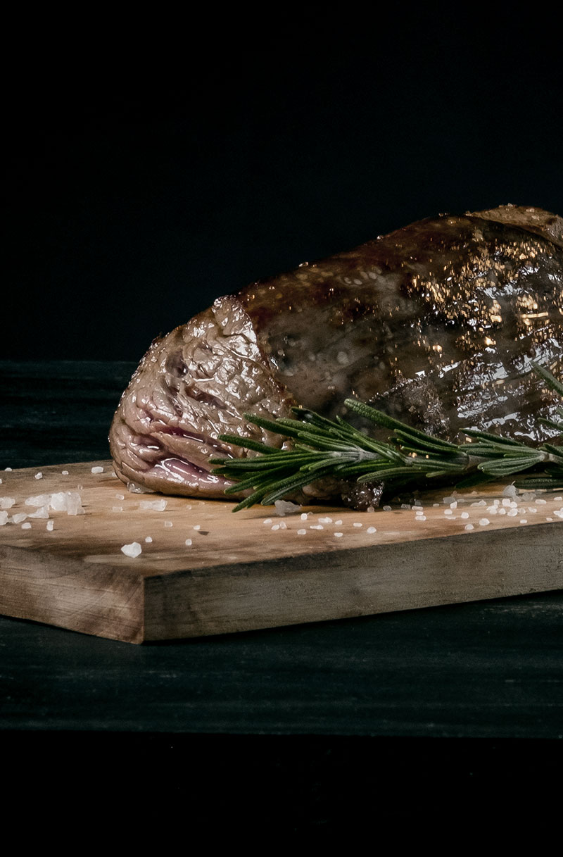 A rib of beef rested on an oak board
