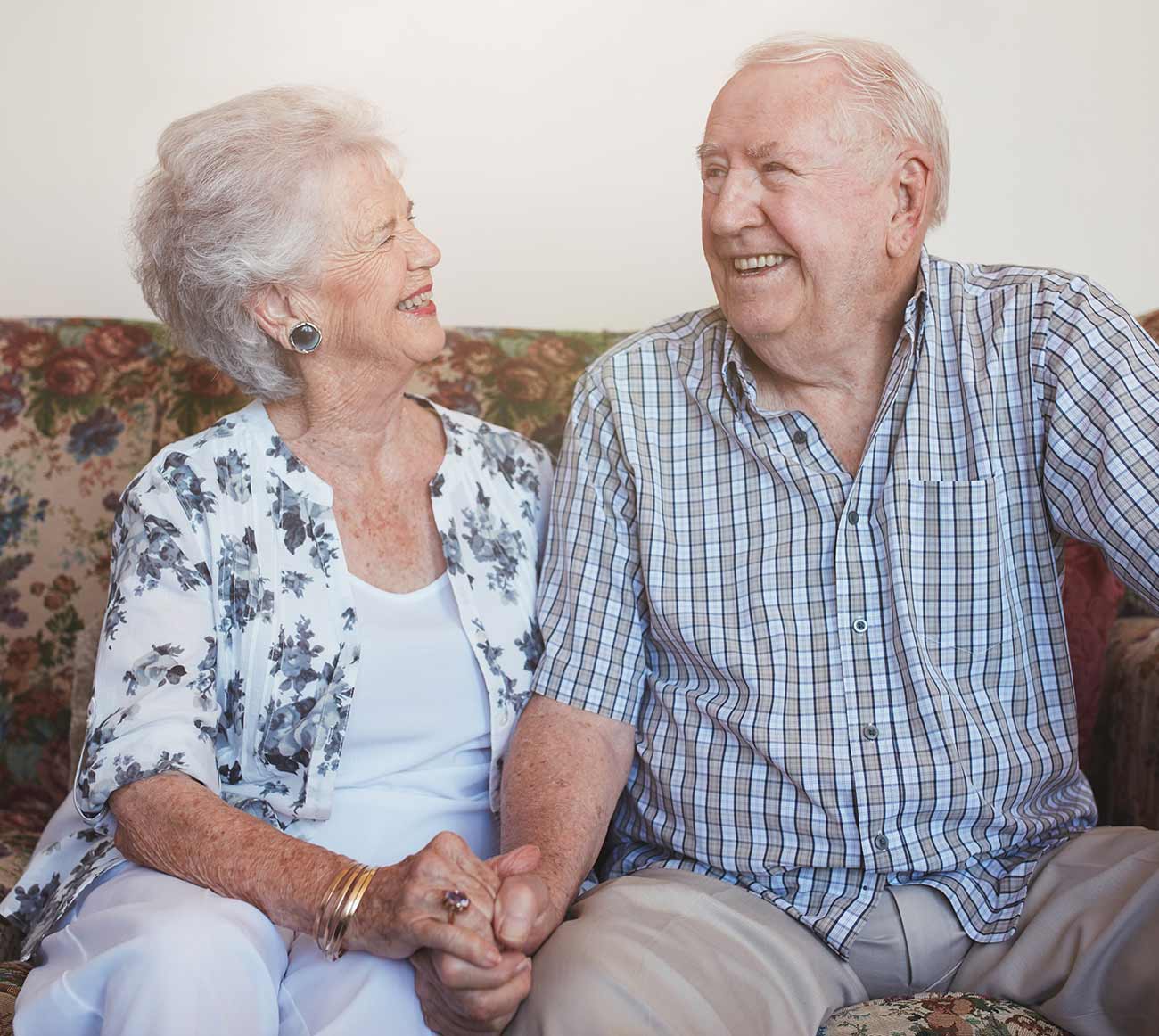 A resident couple laughing together on the sofa