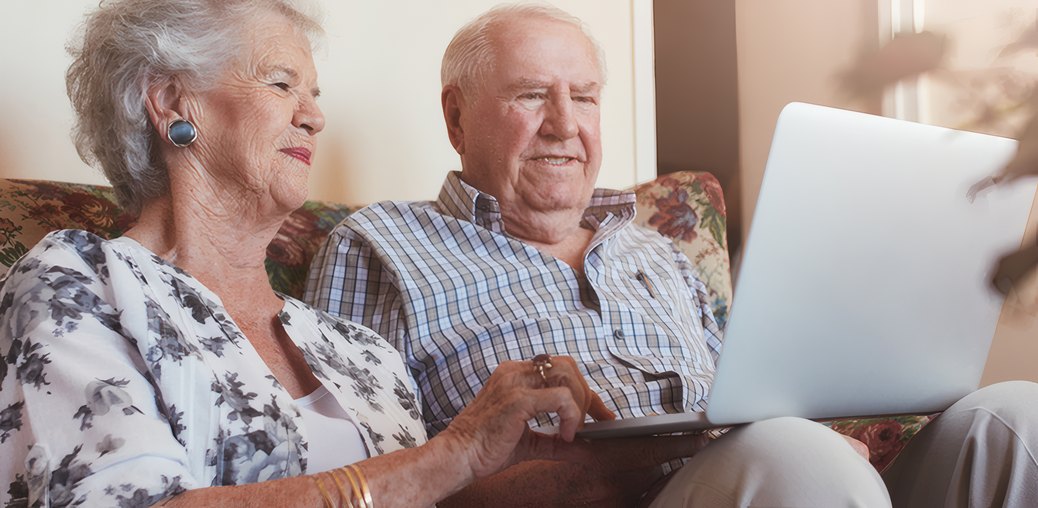 An older couple looking at a laptop together