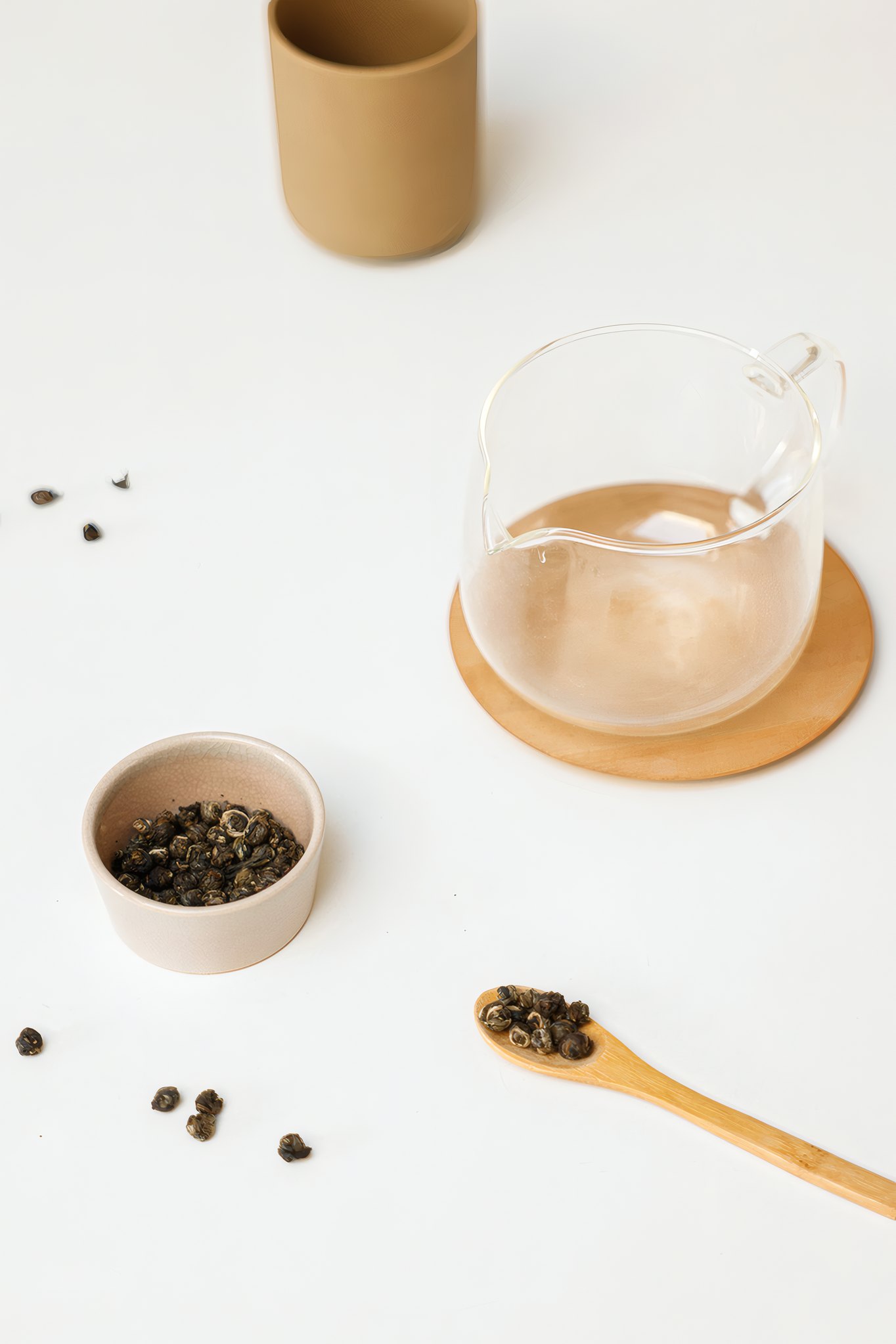 A glass pitcher, loose leaf and a bamboo spoon