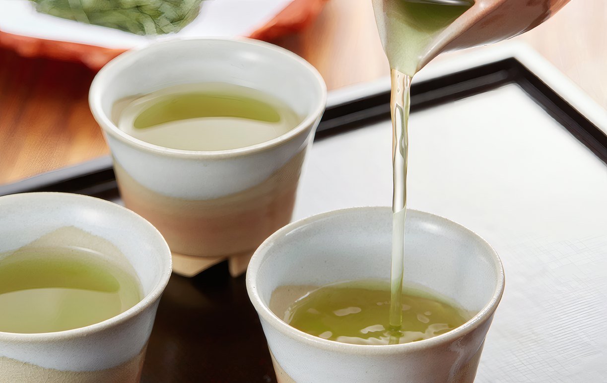 Green tea poured into three ceramic cups