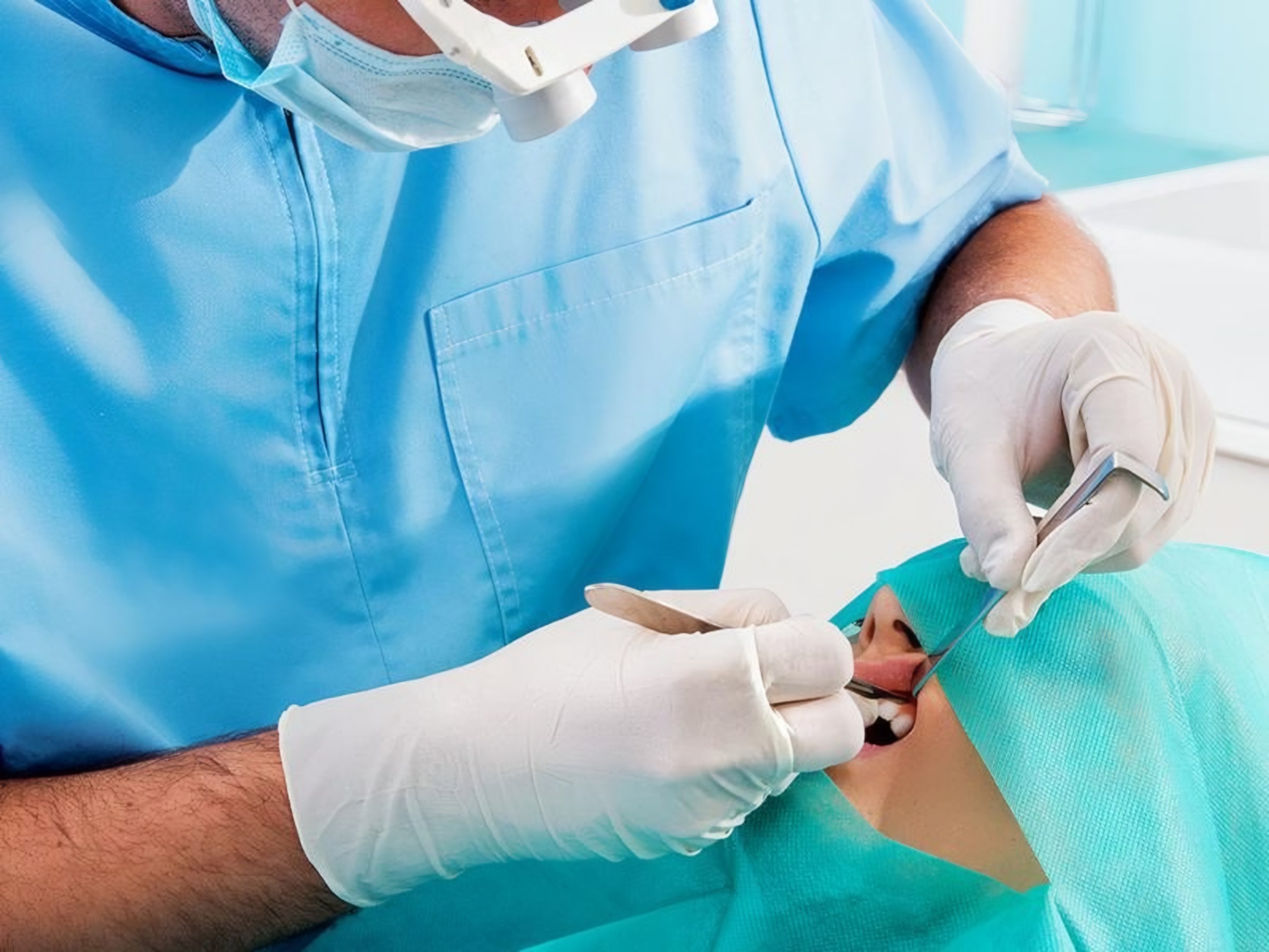 A dentist works on a patient's tooth