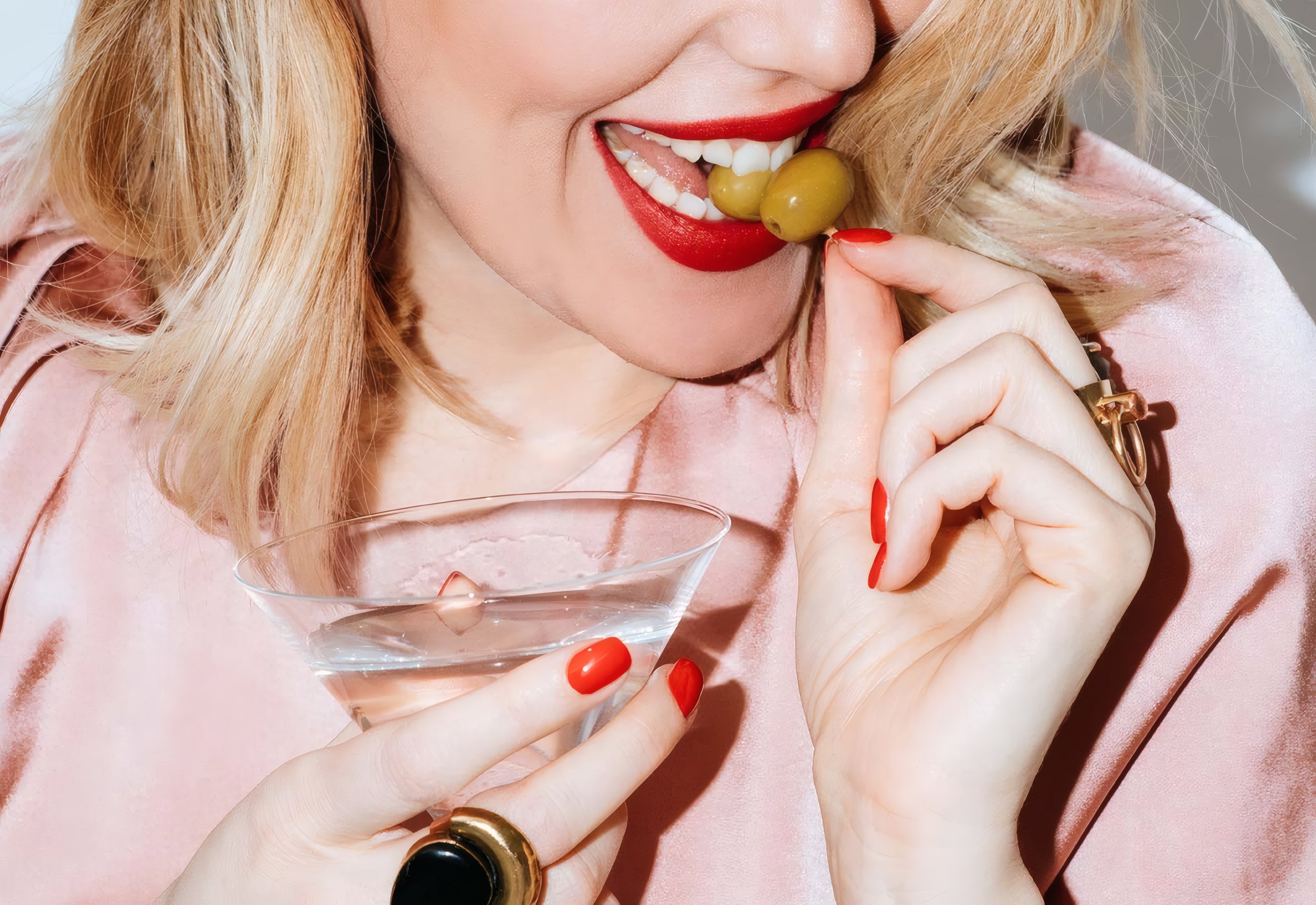 A client in soft pink at a dinner, laughing