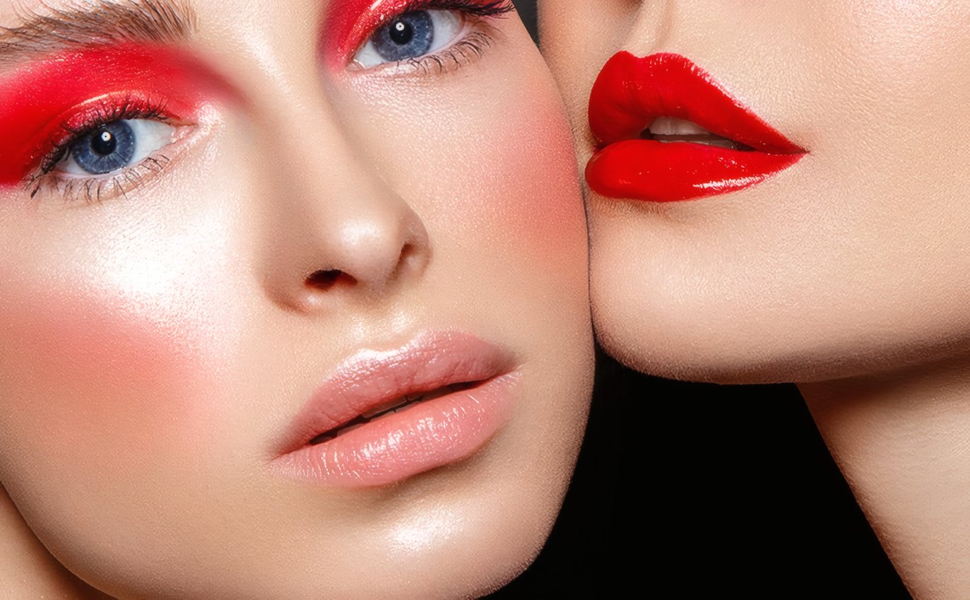 Two faces in bright red and rose make-up