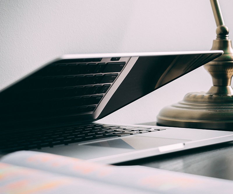 A laptop and a desk lamp in soft light