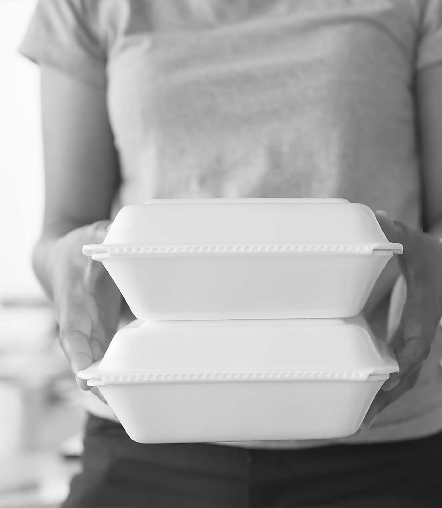 A courier holding two hot takeaway boxes