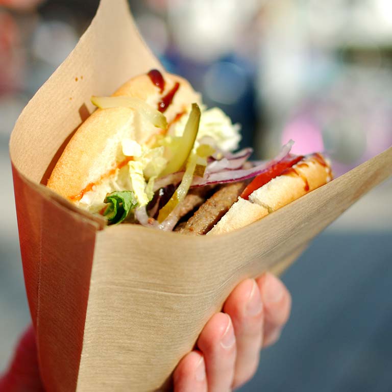 A wrap in a paper cone held in one hand