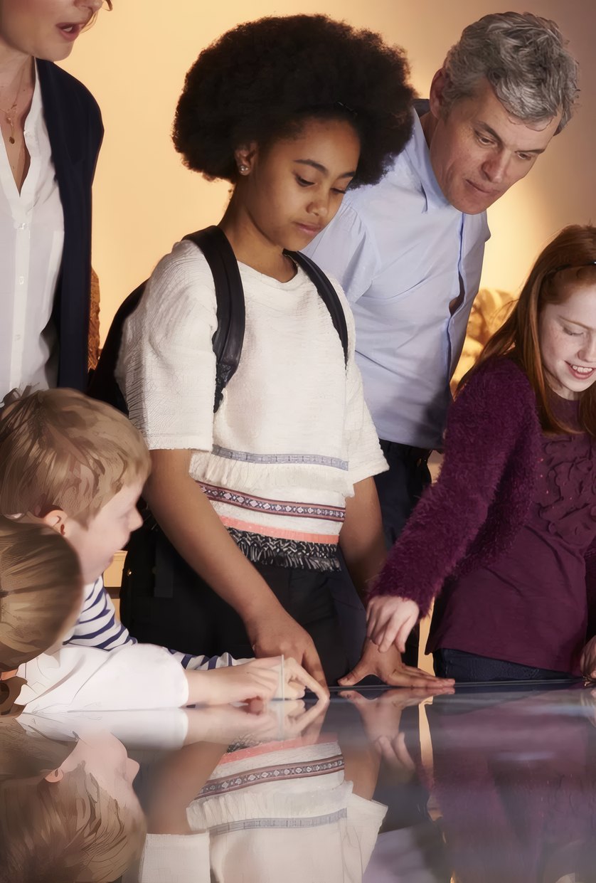 A family leaning over a table case