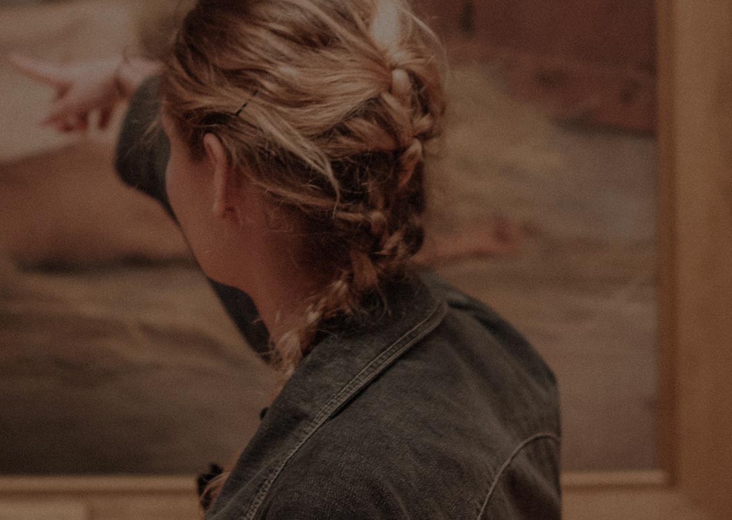 A visitor studying a painting up close