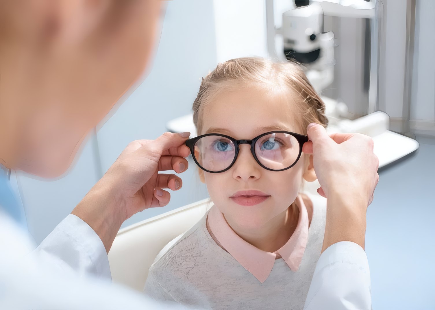 A doctor fitting glasses on a young girl