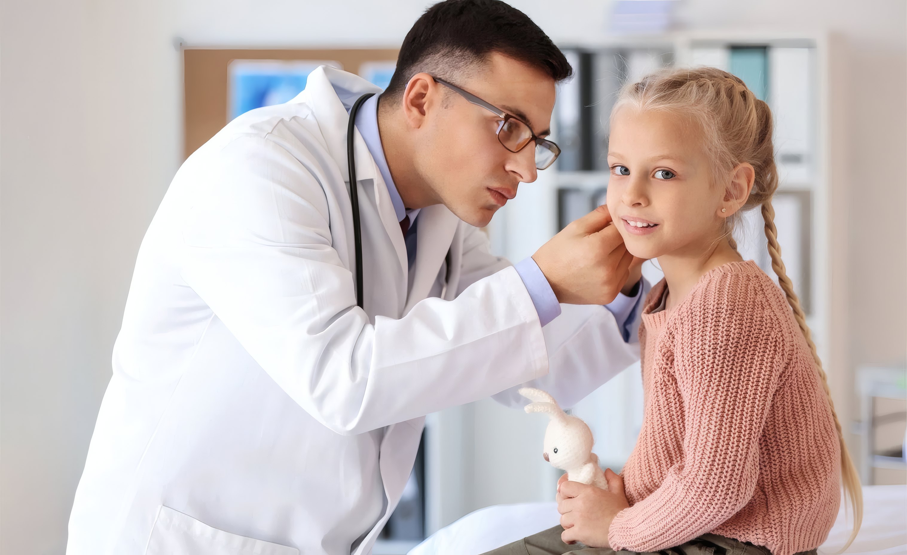 A doctor checking a young girl's ear