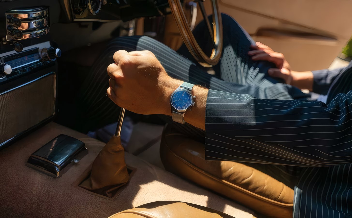 A man at the wheel of a car, a watch on his wrist