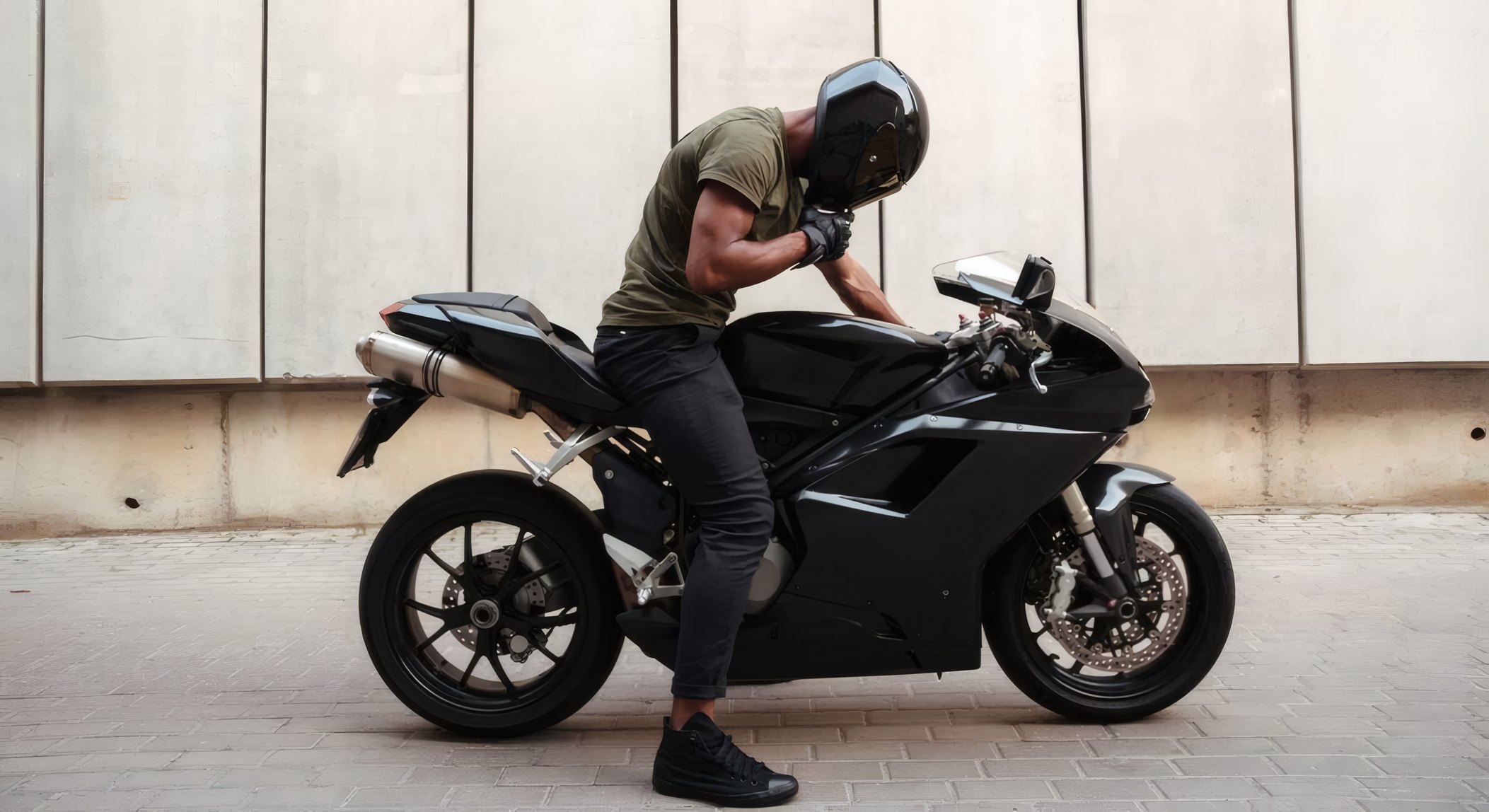 A man in a field jacket beside a black motorcycle