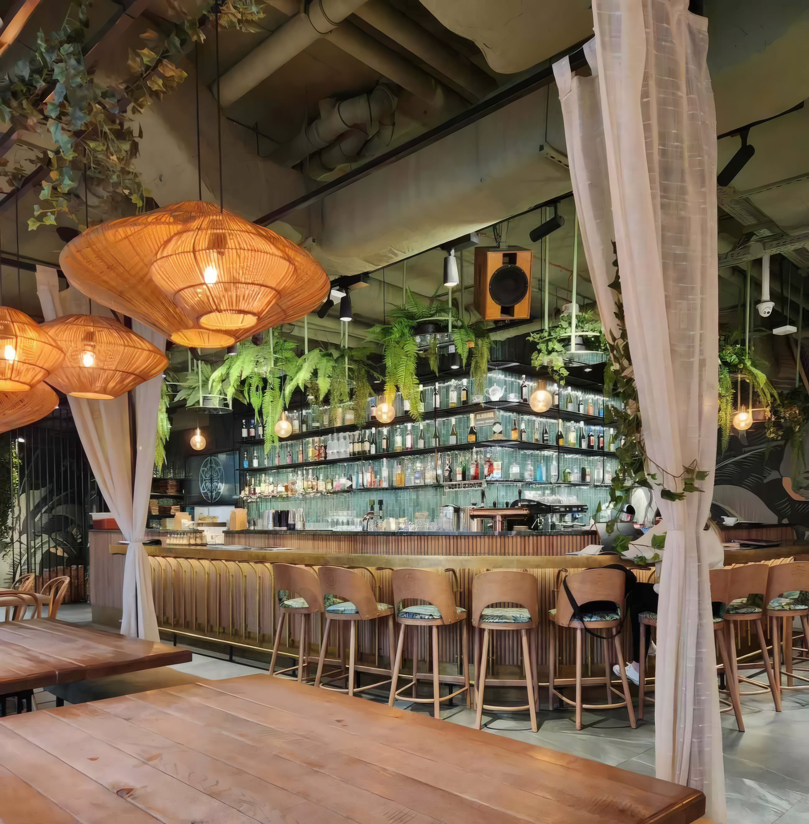 The long bar under rattan lamps, bottles to the ceiling