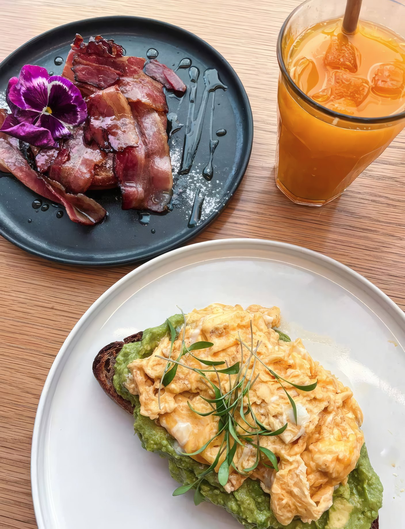 Eggs on avocado toast, ham and a fresh orange juice for breakfast