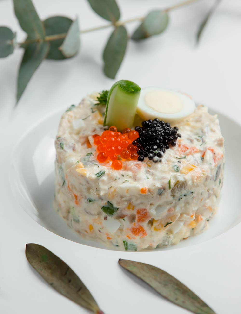 A layered salad topped with caviar