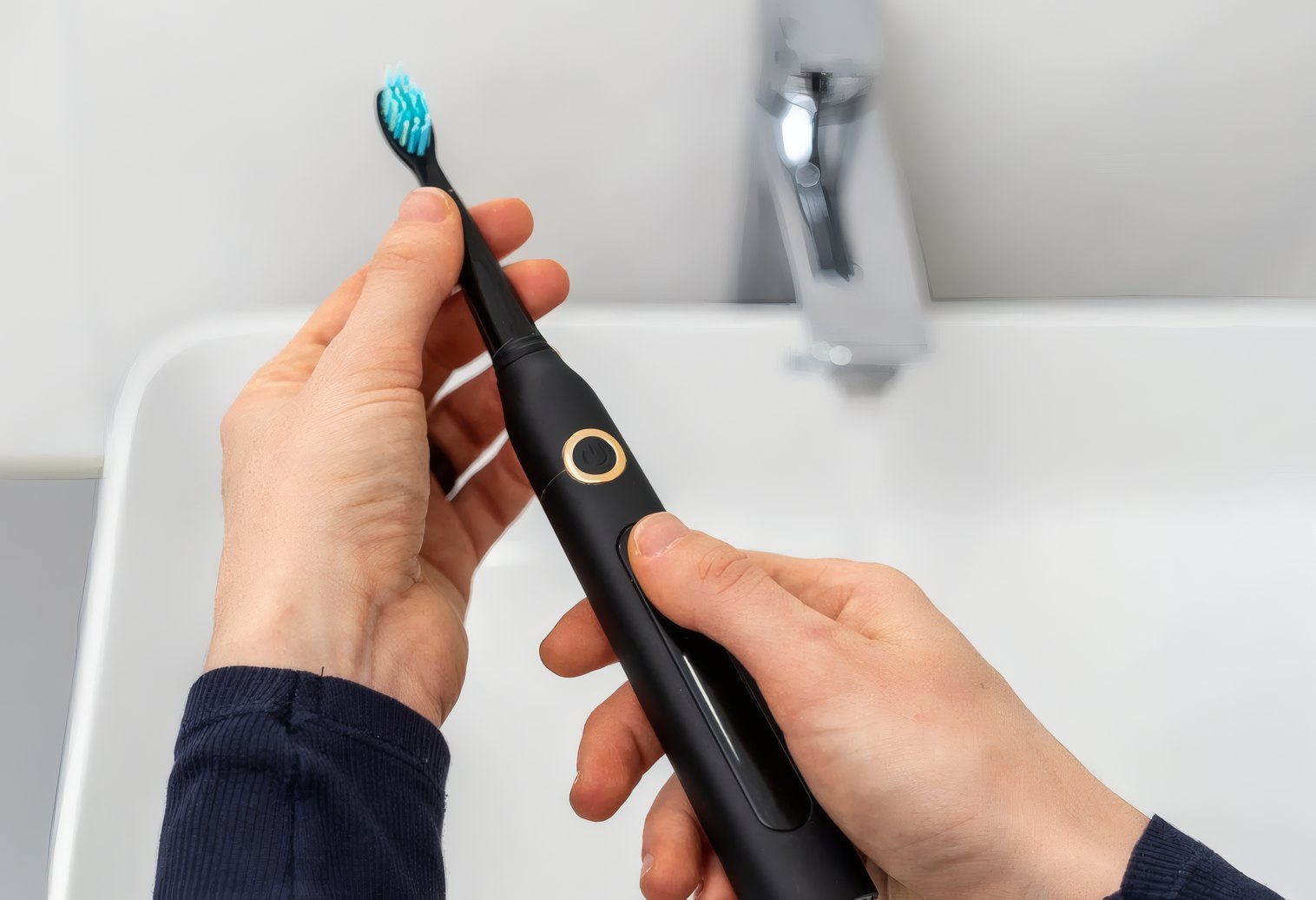 An electric toothbrush beside the bathroom sink