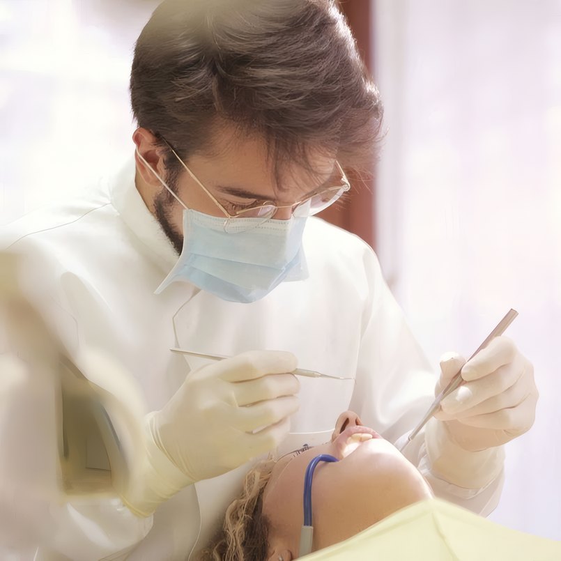 A dentist at work in mask and gloves