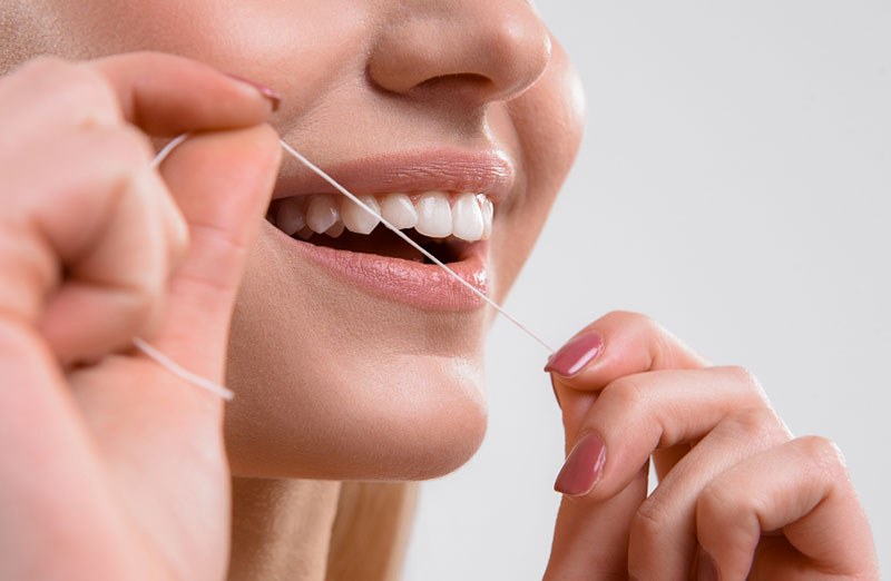 A woman flossing her teeth