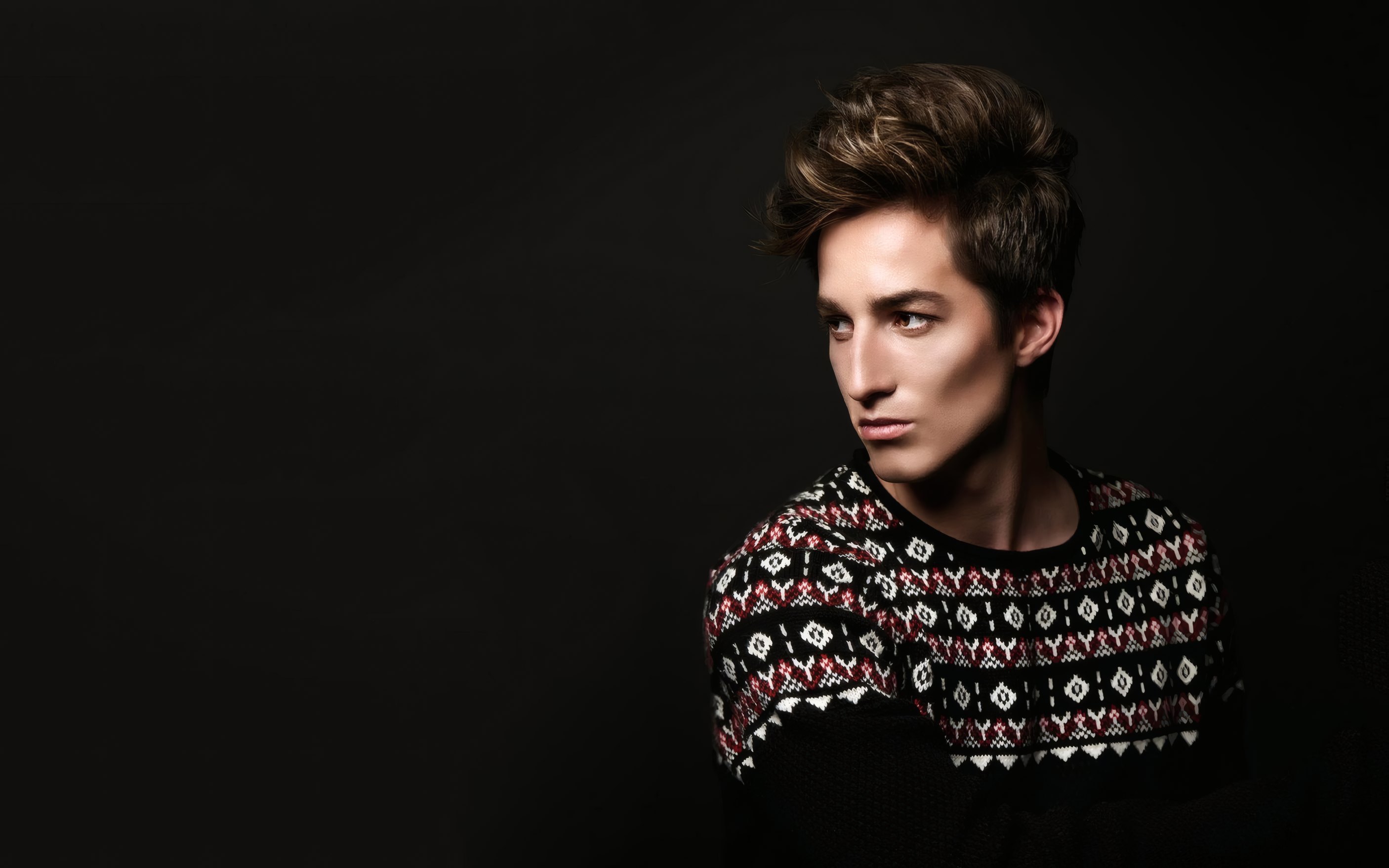 Luca Ferrand in a patterned sweater against black