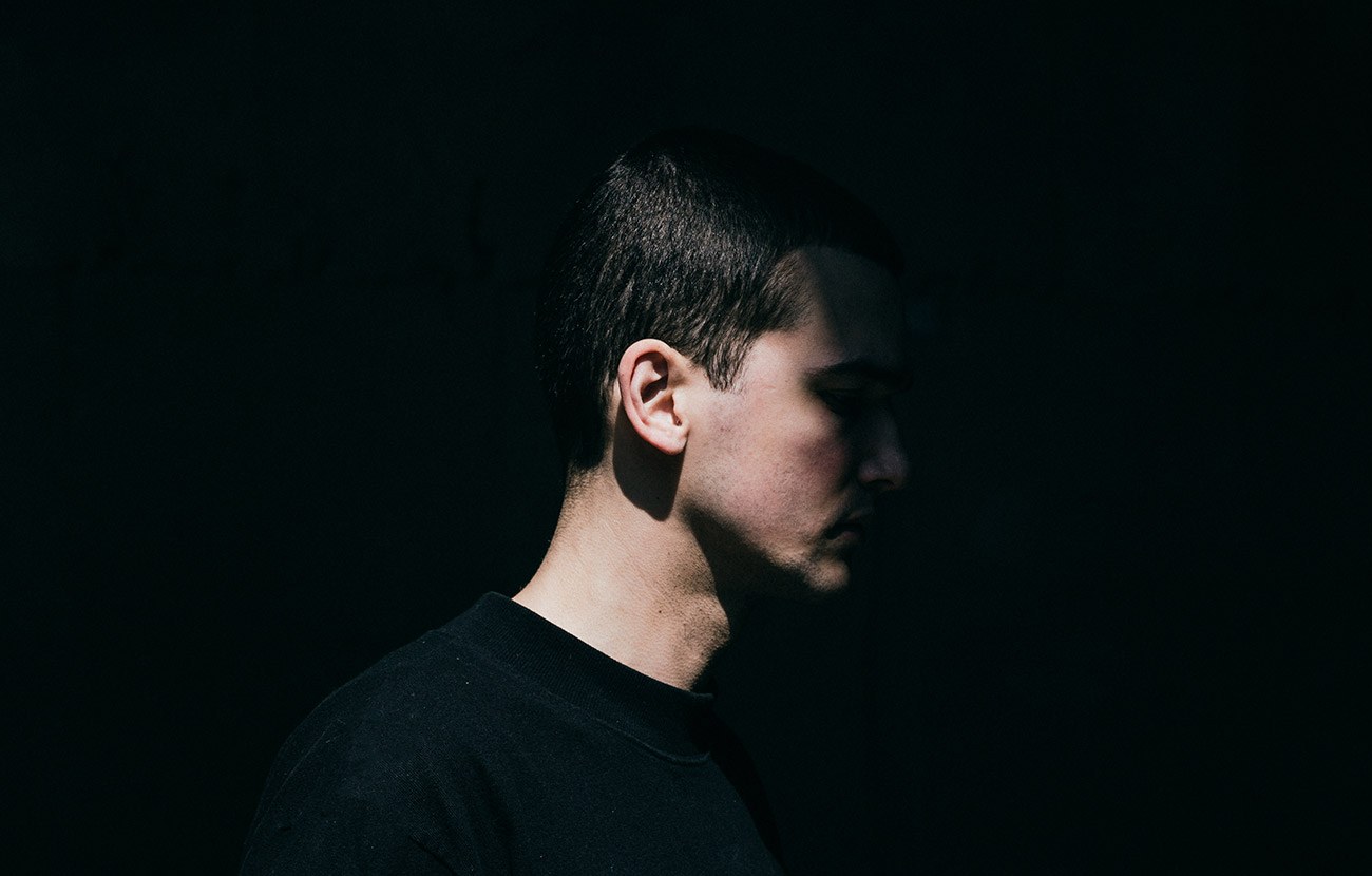 A male model in profile on black