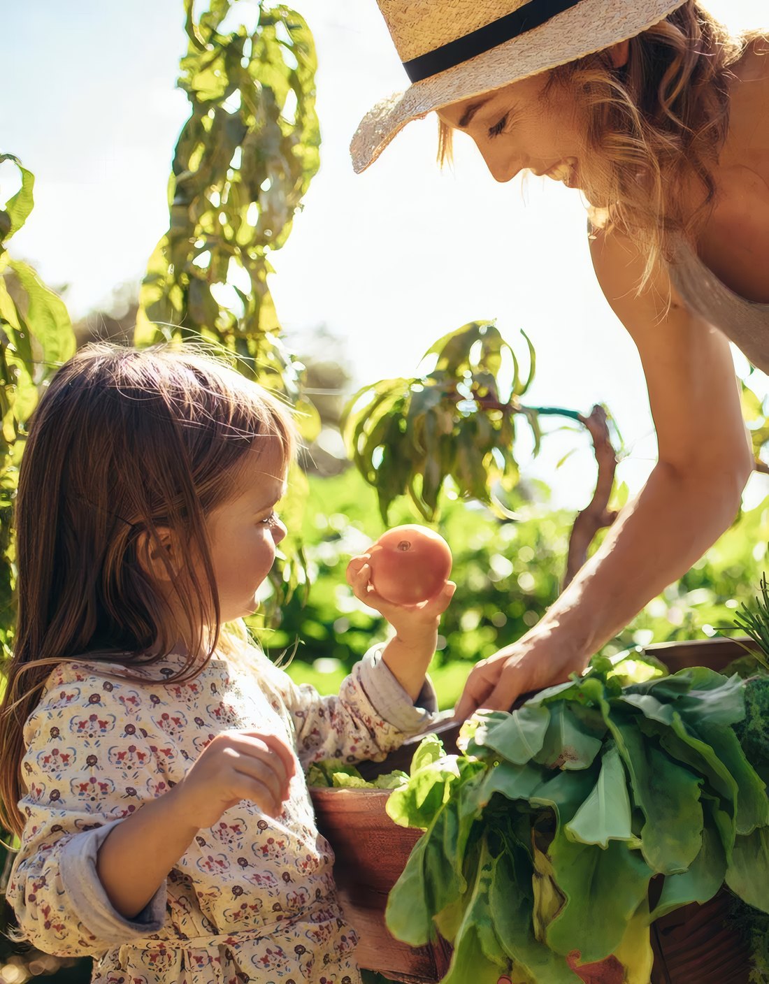 A mother and her daughter picking greens in the garden