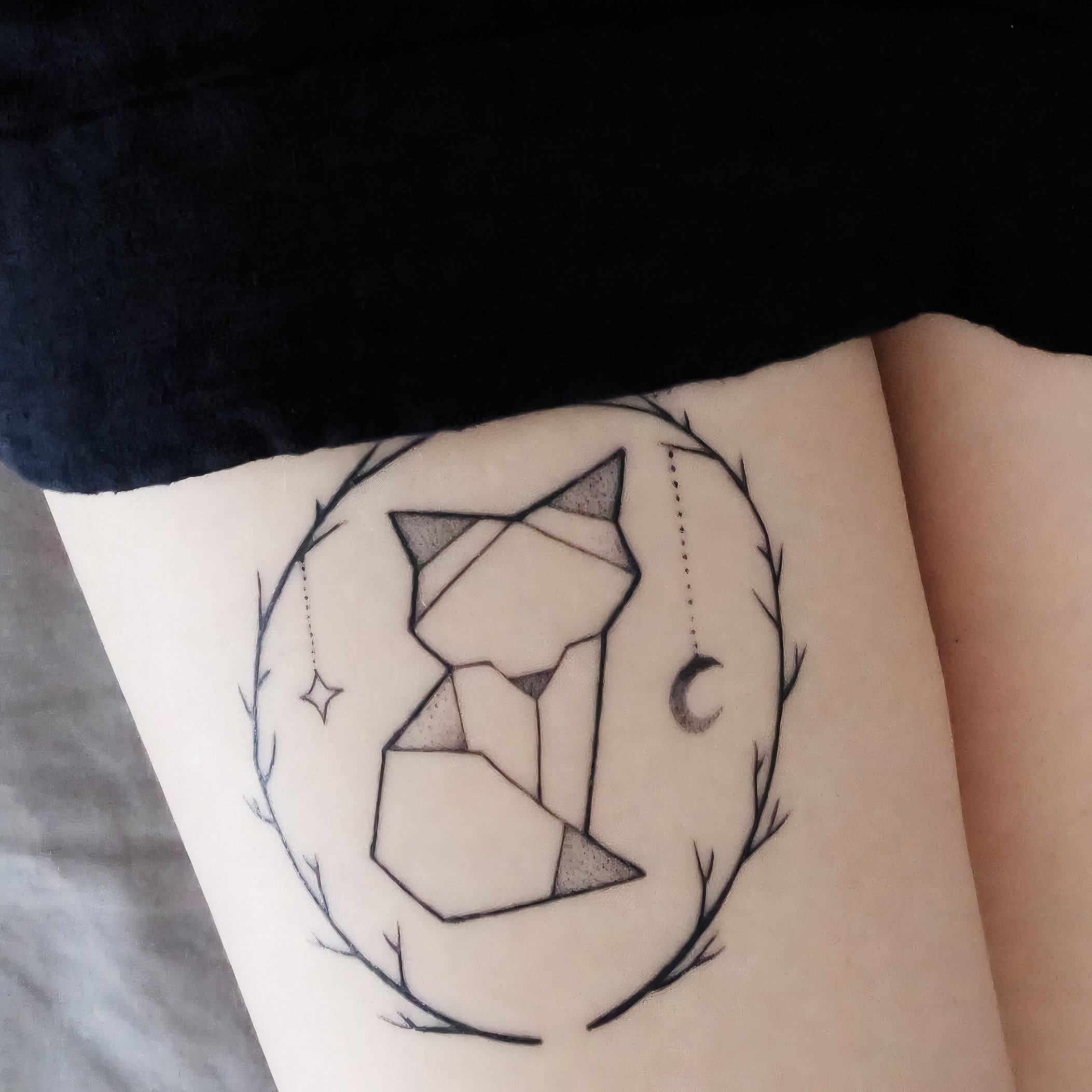 A geometric fine-line fox on an upper arm