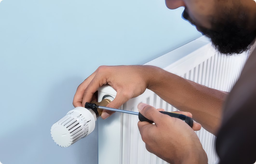 A hand turning off a valve on the pipework