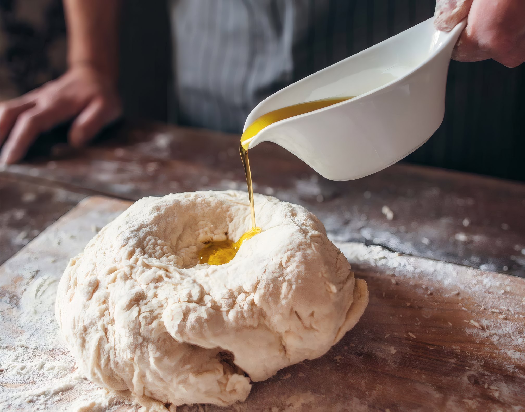 Olive oil poured into a well of dough
