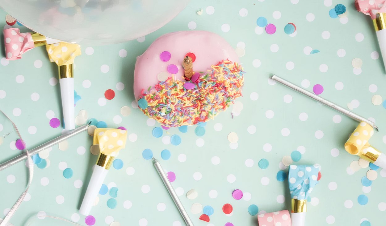 A sprinkle donut on a polka dot table