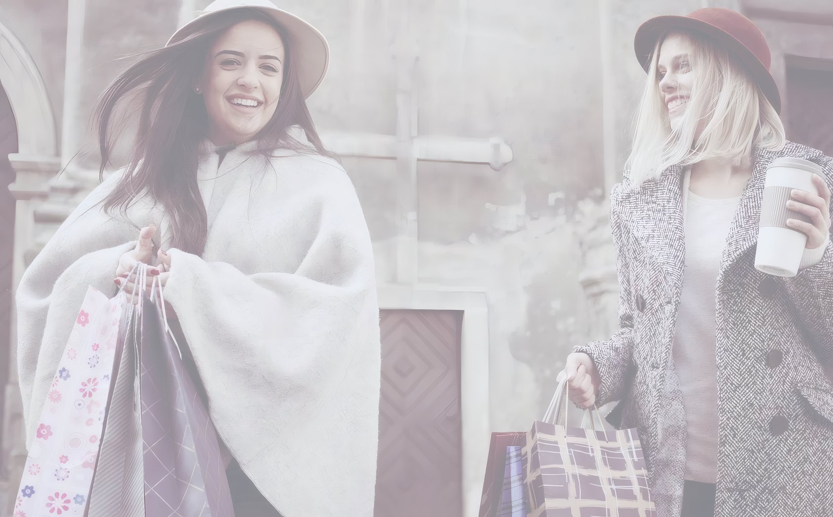 Two friends laughing outside, shopping bags in hand