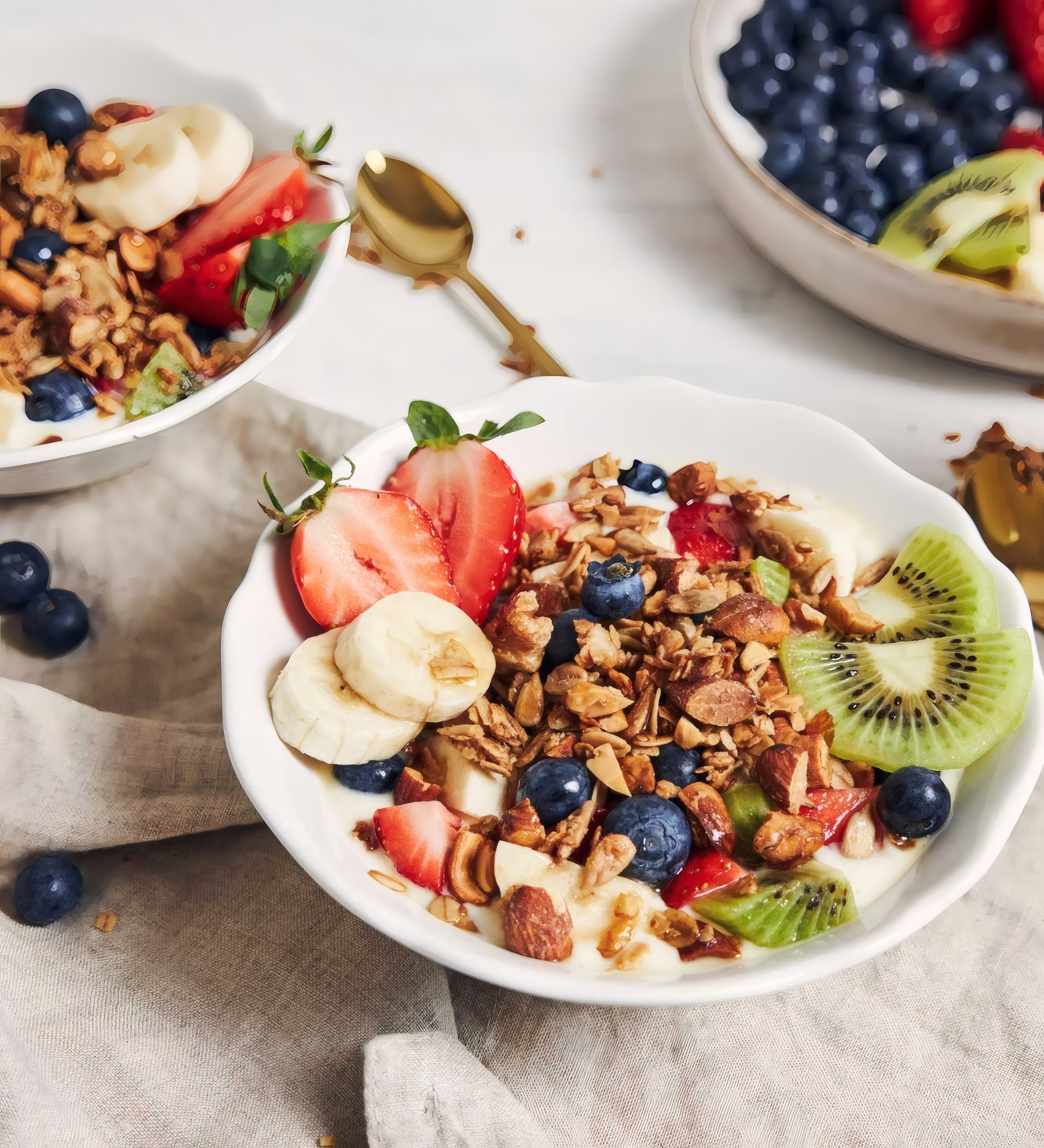 A bowl of granola with strawberries, banana and kiwi
