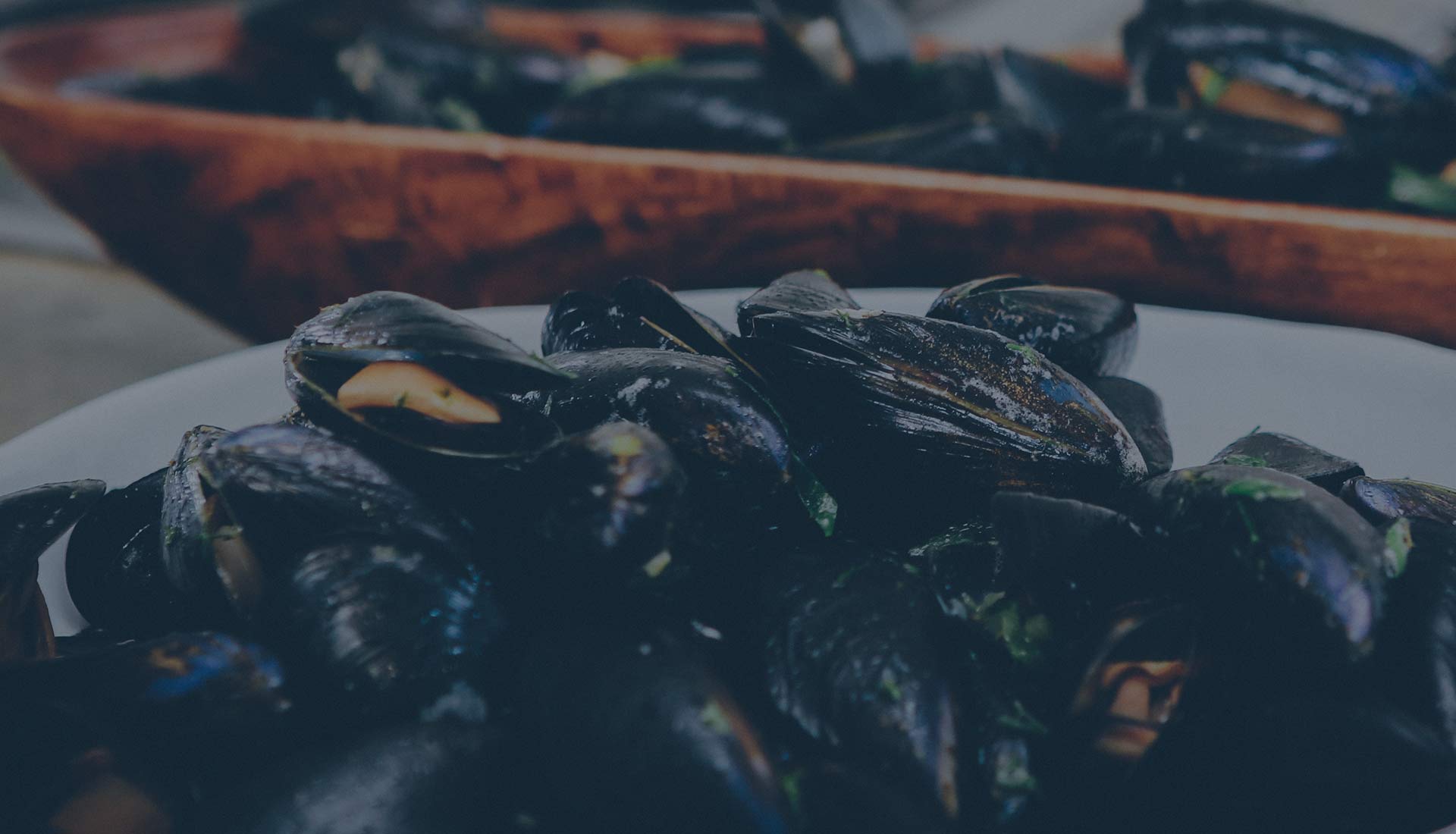 A dark pan of mussels with parsley