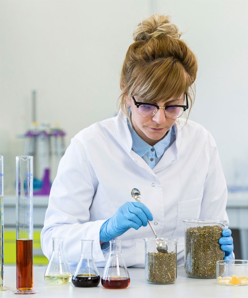 An analyst weighing dried hemp flower at a laboratory bench