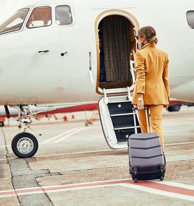 A traveller with a suitcase stepping up into a light jet