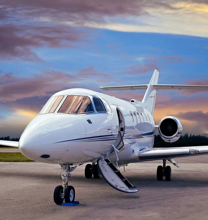 A private jet on the apron at dusk, airstairs down