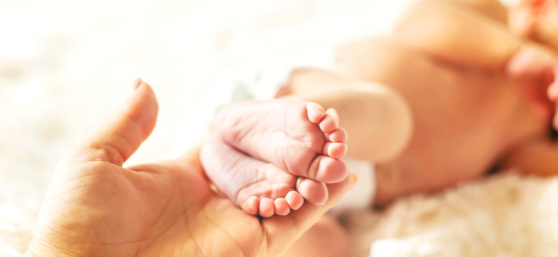 A parent holding a baby's feet