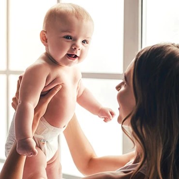 Mother lifting her smiling baby