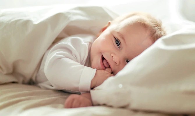 Baby lying on soft pillows and smiling