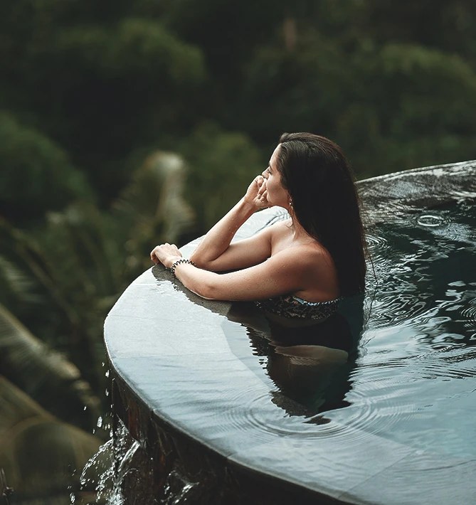 A guest resting at the edge of the jungle infinity pool