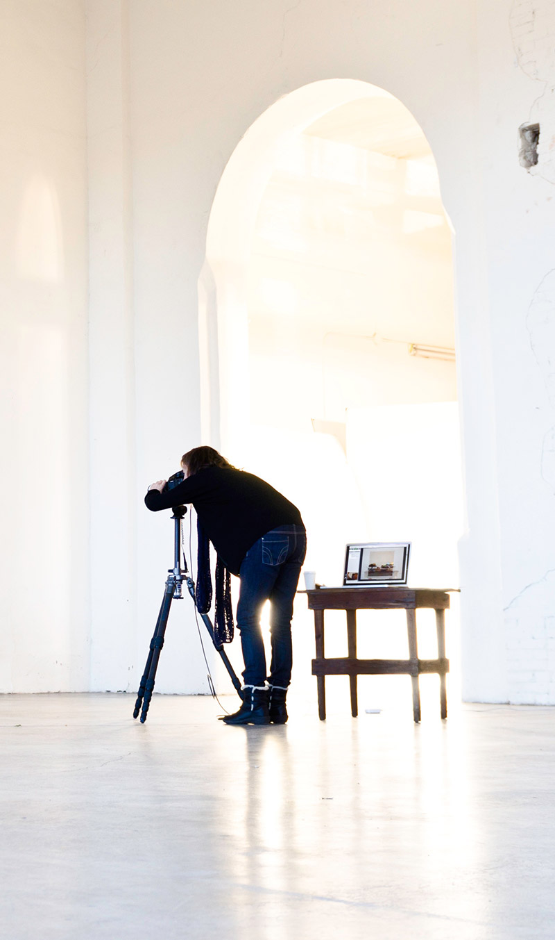A photographer setting up a tripod in a bright hall