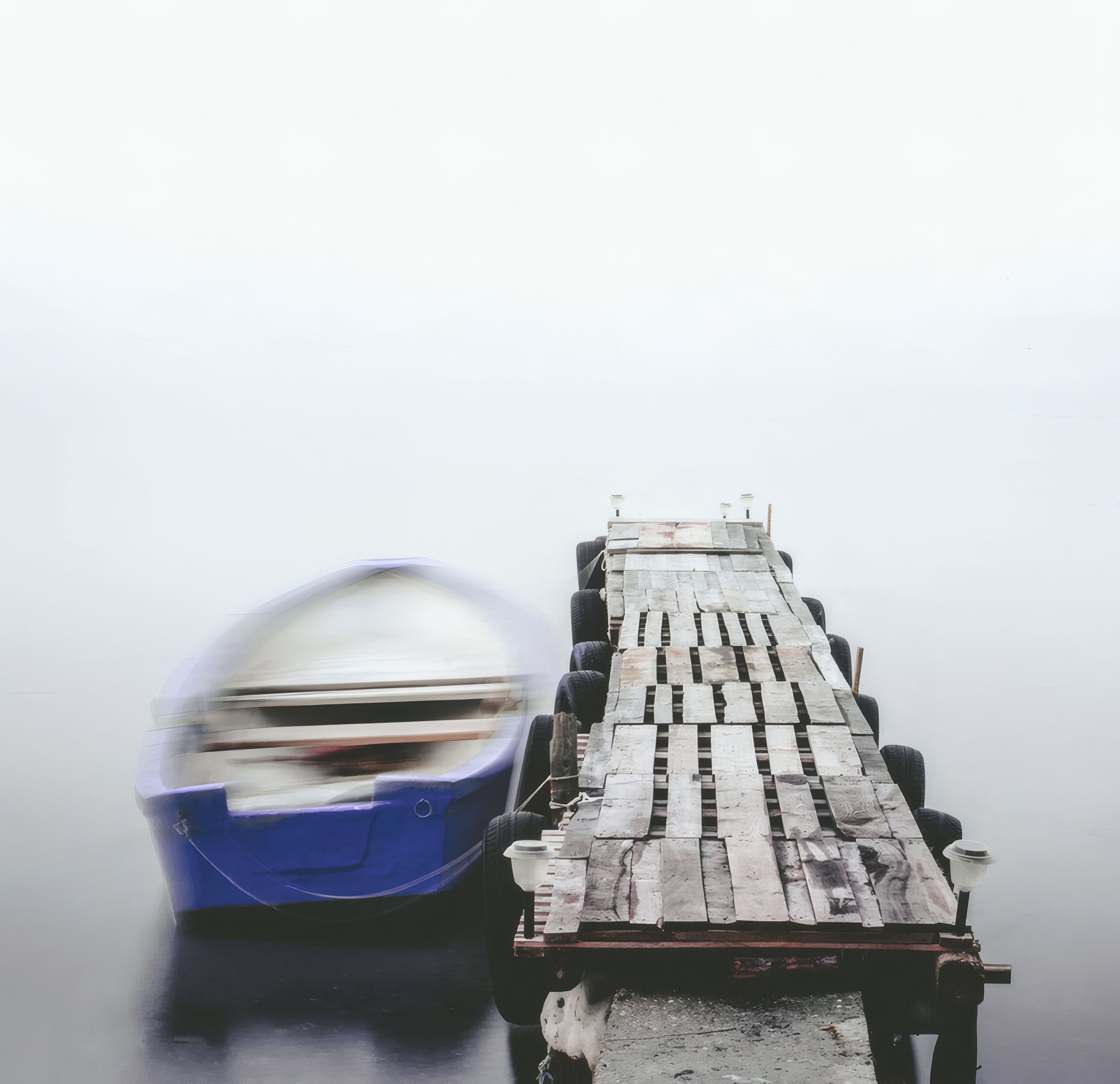 A boat at a jetty in the fog