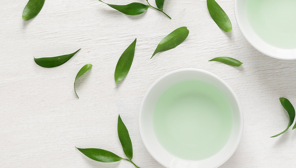 A cup of green tea on a white table