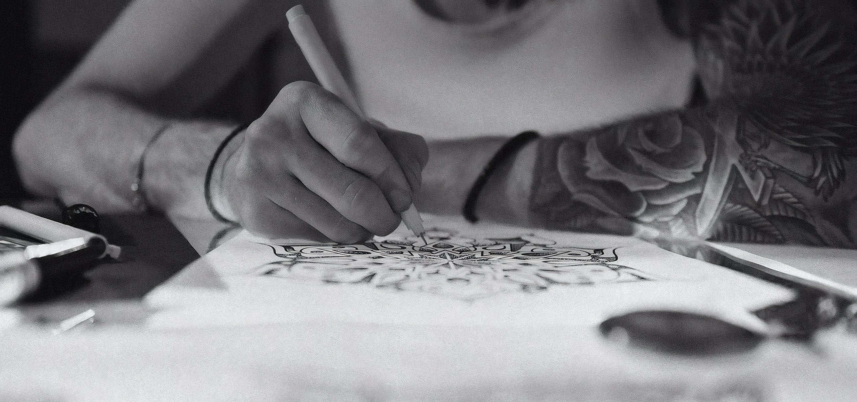 An artist drawing a design in pencil