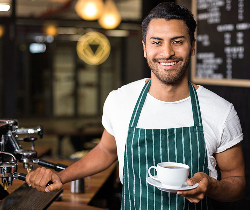 A barista holding a cup of coffee