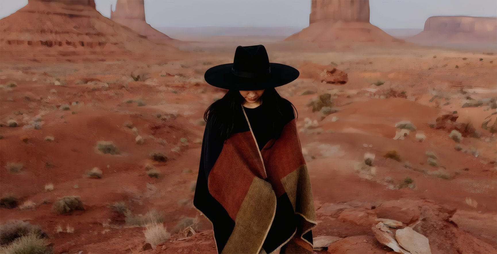 A rancher in a wide hat on the red plateau, from The Long Dry