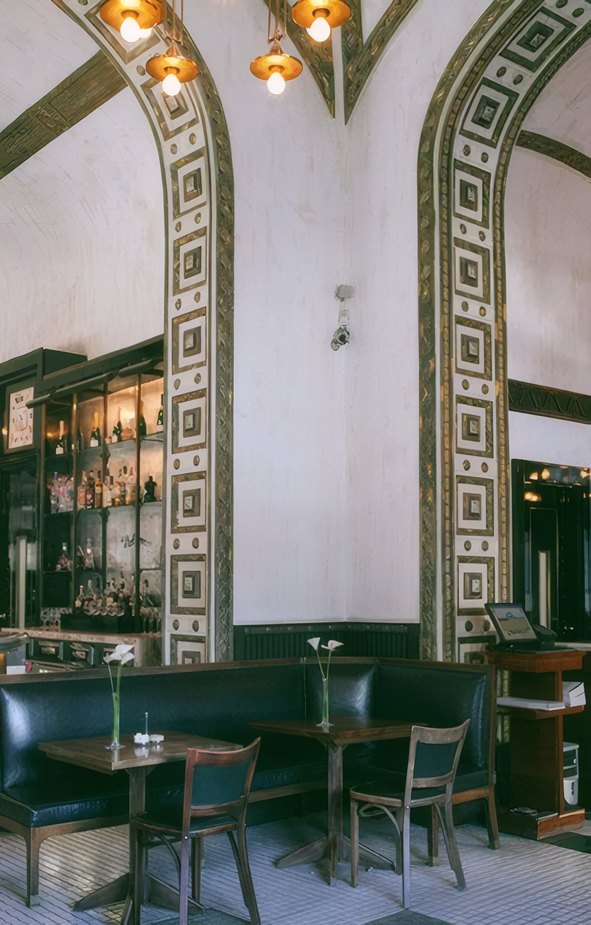 Green booths and arched mirrors in the dining room